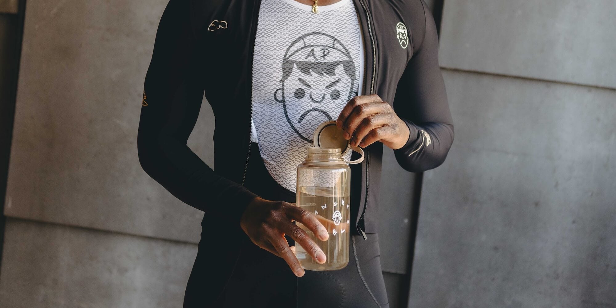 A cyclist wearing a White Angry Pablo Mesh Base Layer and holding a Nalgene bottle